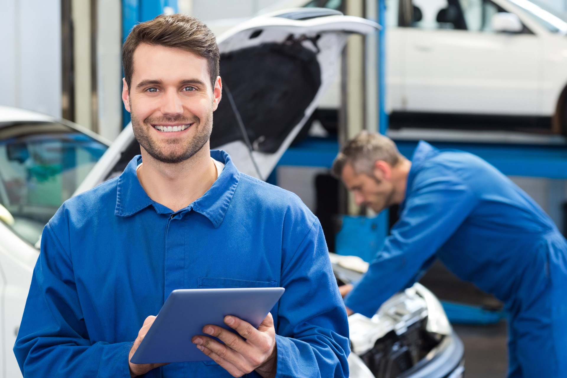 Young man using a tablet in a mechanic's workshop